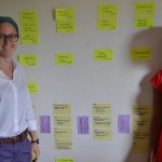 Interns Ellie Sell and Ada Oambi use sticky notes to plan out their public health curriculum