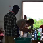 Summer intern Ellie Sell demonstrates how to use a microscope to students