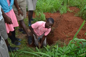 Students dig a hole for the compost